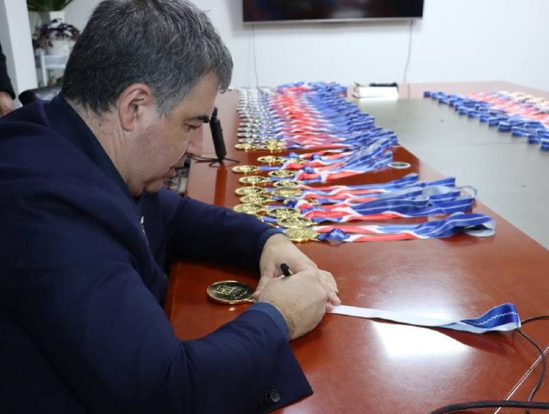 Константин Новоселов олимпиадад амжилттай оролцсон сурагчдын медалийн бүчин дээр гарын үсгээ зуржээ